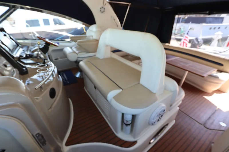 Slide: The Image of 2004 Sea Ray 420 Sundancer interior with helm, seating, and wooden flooring. - 19