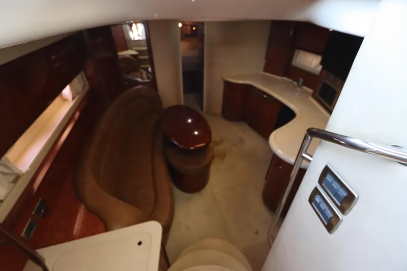 Slide: The Image of 2004 Sea Ray 420 Sundancer interior with curved seating and kitchenette. - 26
