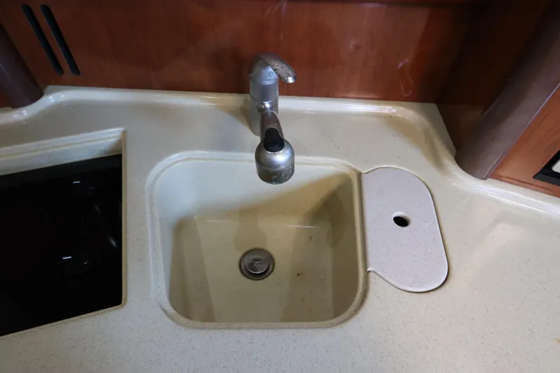 Slide: The Image of Kitchen sink area in 2004 Sea Ray 420 Sundancer yacht, featuring a modern faucet. - 32