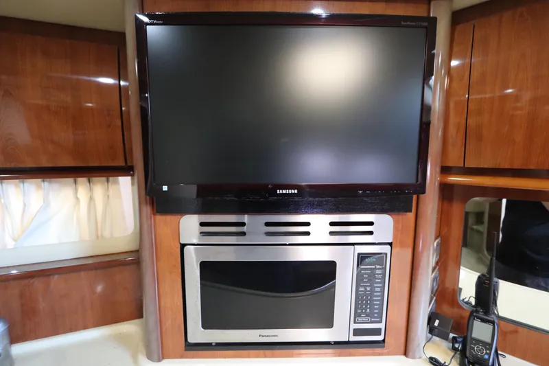 Slide: The Image of Entertainment and kitchen area in 2004 Sea Ray 420 Sundancer yacht, featuring TV and microwave. - 34
