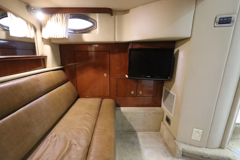 Slide: The Image of 2004 Sea Ray 420 Sundancer interior with leather seating, wood cabinetry, and mounted TV. - 48