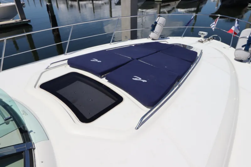 Slide: The Image of 2004 Sea Ray 420 Sundancer yacht with sun pads on deck, docked at marina. - 8