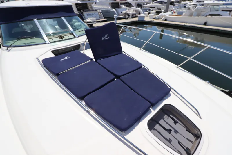 Slide: The Image of 2004 Sea Ray 420 Sundancer with blue sun pads on deck, docked at marina. - 9