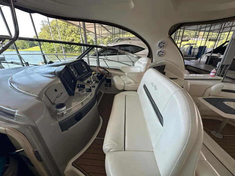 Slide: The Image of 2005 Sea Ray 420 Sundancer cockpit with white seating and modern dashboard controls. - 14