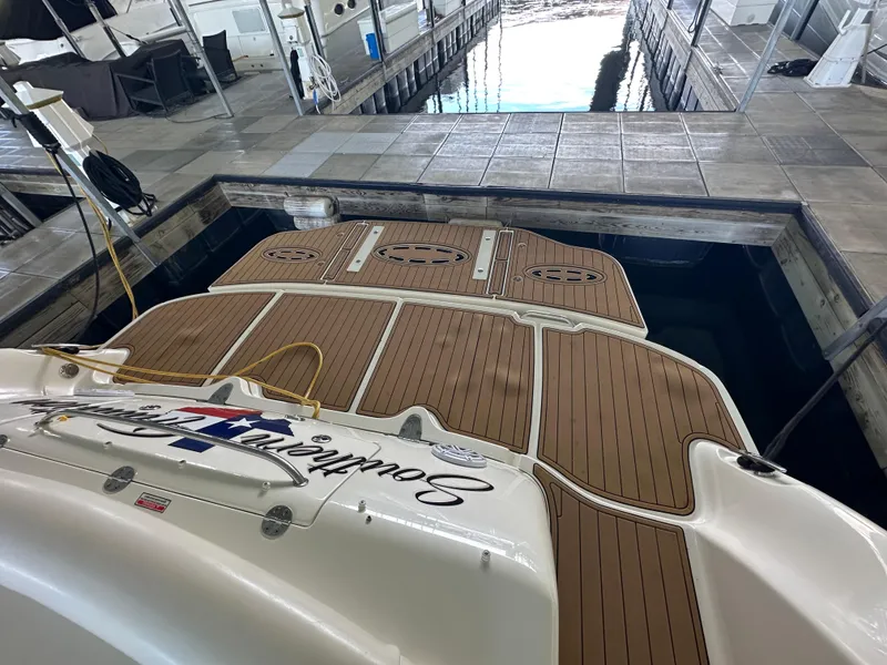 Slide: The Image of 2005 Sea Ray 420 Sundancer docked, showcasing teak swim platform and marina setting. - 25