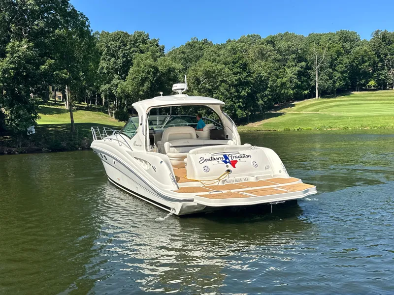 Slide: The Image of 2005 Sea Ray 420 Sundancer yacht on a serene lake with lush green surroundings. - 3