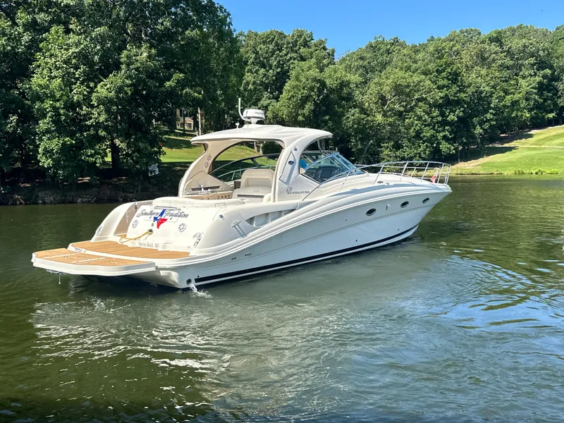 Slide: The Image of 2005 Sea Ray 420 Sundancer yacht cruising on a serene lake with lush green surroundings. - 5