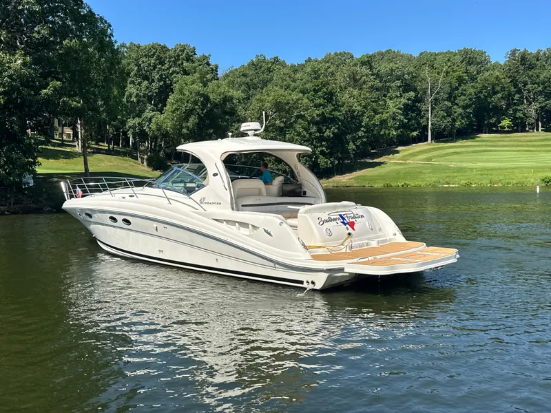 Slide: The Image of 2005 Sea Ray 420 Sundancer yacht on a serene lake with lush green surroundings. - 6