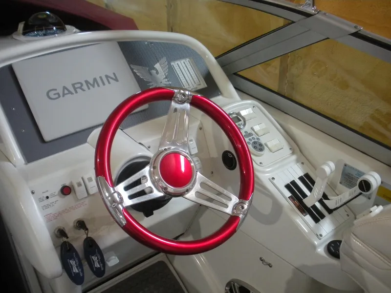 Slide: The Image of 2001 Fountain 35 Fastech boat dashboard with red steering wheel and Garmin navigation system. - 7