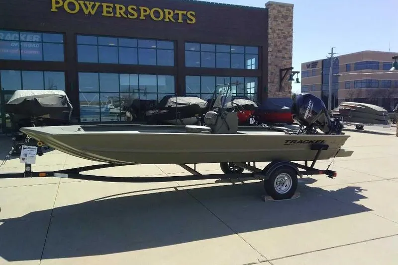 The Image of 2026 Tracker Grizzly 1860 CC boat displayed outside Powersports dealership. - 0