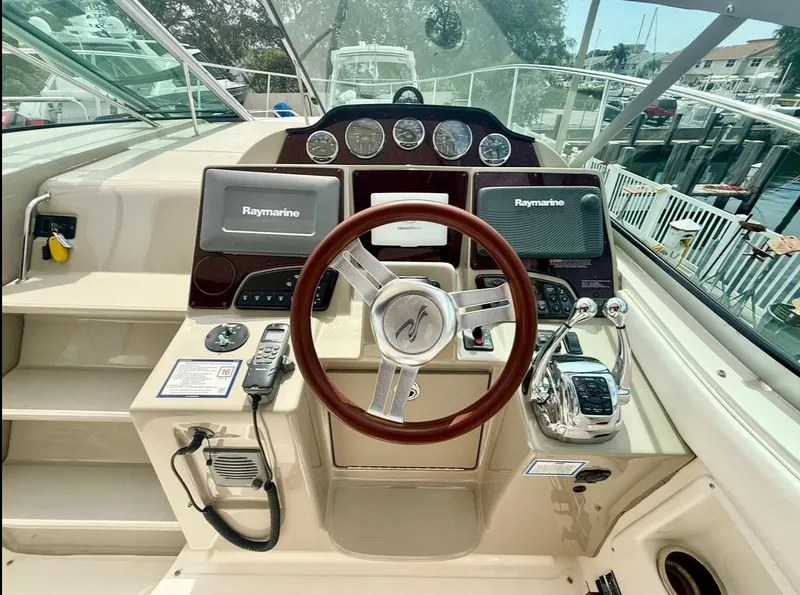 Slide: The Image of 2011 Sea Ray 350 Sundancer helm with Raymarine electronics and polished steering wheel. - 11