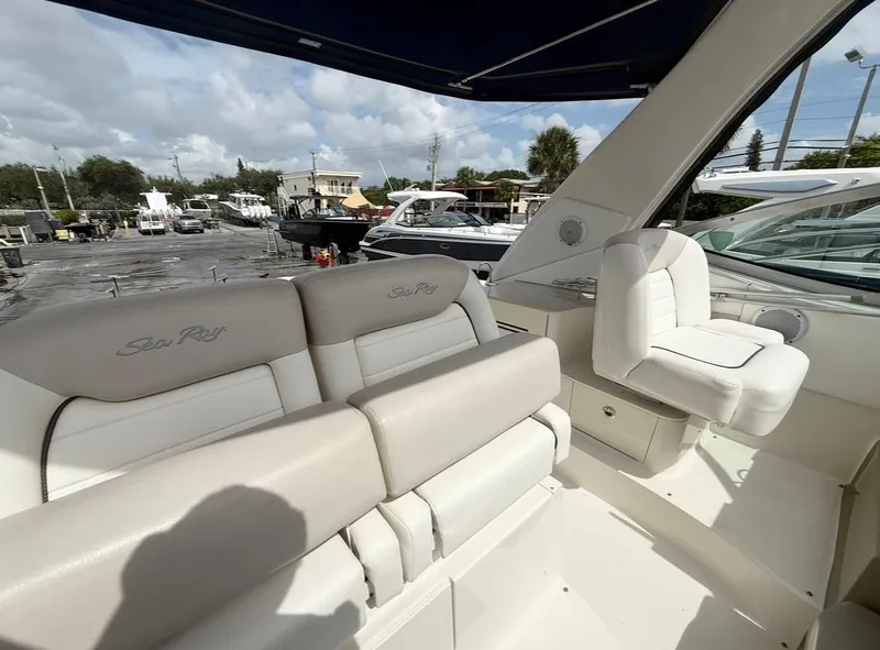 Slide: The Image of 2011 Sea Ray 350 Sundancer interior with plush seating and helm, docked at marina. - 12