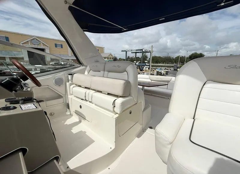Slide: The Image of 2011 Sea Ray 350 Sundancer boat interior with white seating and steering area. - 13