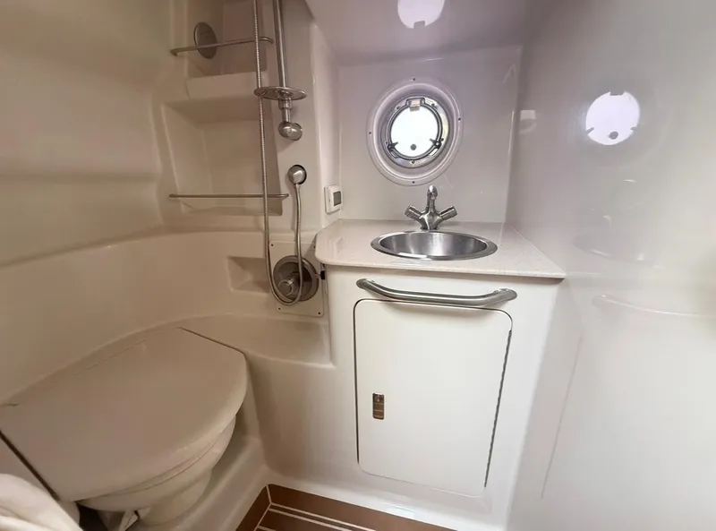 Slide: The Image of 2011 Sea Ray 350 Sundancer bathroom with sink, toilet, and porthole window. - 20