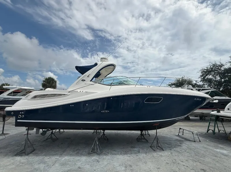 Slide: The Image of 2011 Sea Ray 350 Sundancer boat on stands under a partly cloudy sky. - 25