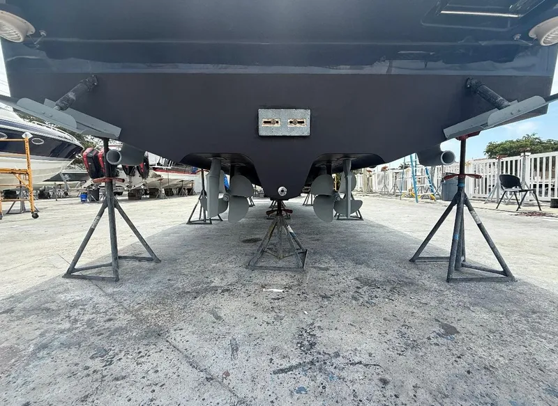 Slide: The Image of 2011 Sea Ray 350 Sundancer on stands, showing propellers and hull in a boatyard. - 26