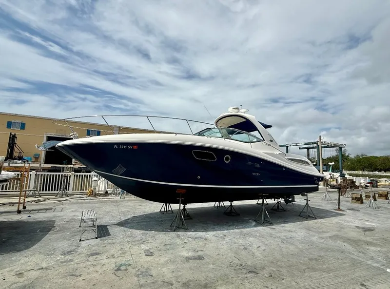 Slide: The Image of 2011 Sea Ray 350 Sundancer yacht on dry dock under cloudy sky. - 27