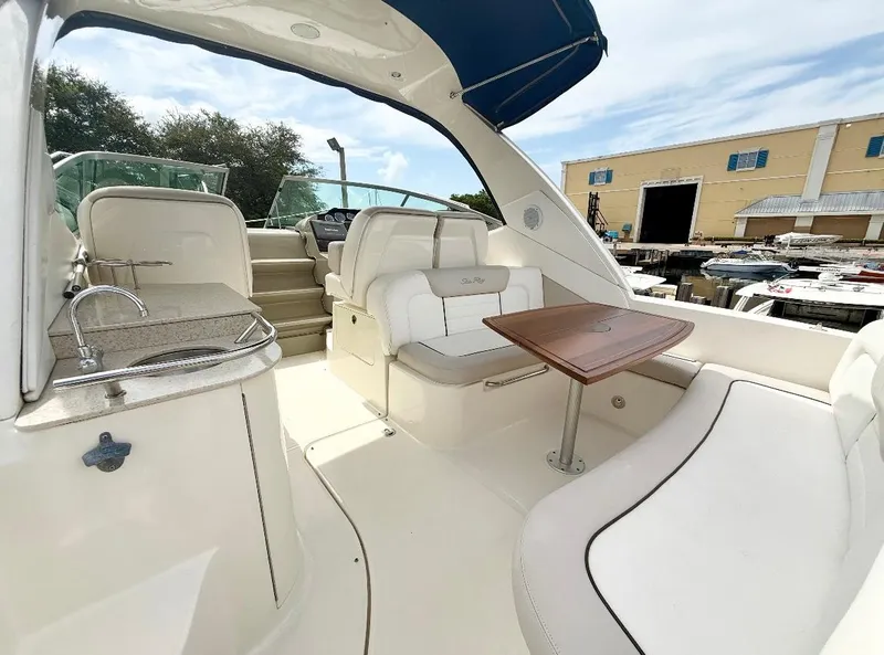 Slide: The Image of 2011 Sea Ray 350 Sundancer boat interior with seating, table, and kitchenette. - 6