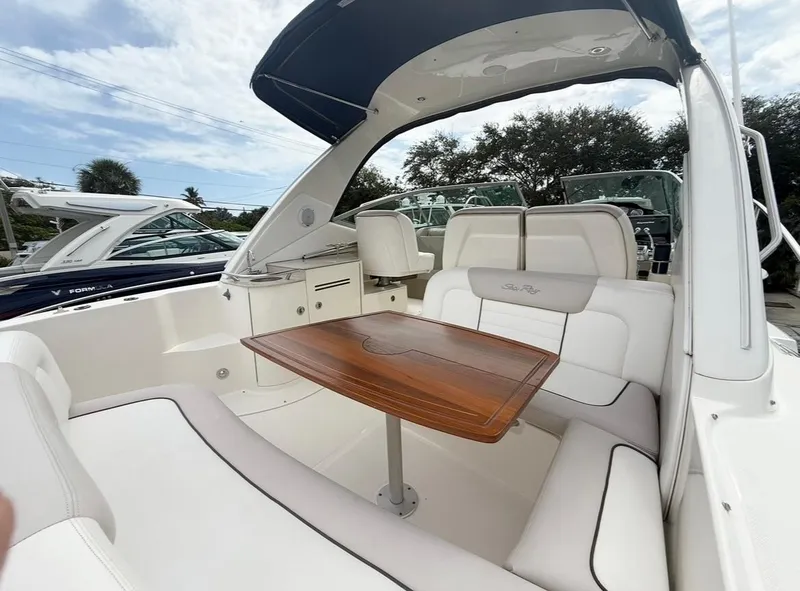 Slide: The Image of 2011 Sea Ray 350 Sundancer boat interior with seating and wooden table. - 7