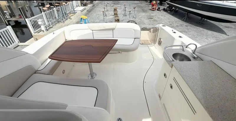 Slide: The Image of 2011 Sea Ray 350 Sundancer cockpit with seating, table, and sink. - 9