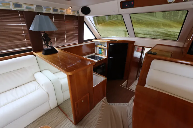 Slide: The Image of The interior of a 2001 Riviera 43 Open Flybridge features a cozy seating area and wooden furnishings. - 38
