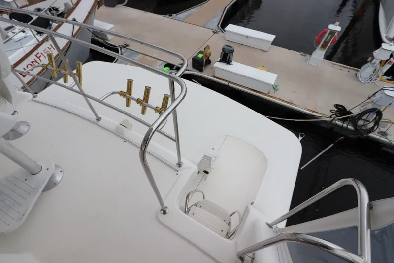 Slide: The Image of The image shows the deck of a 2001 Riviera 43 Open Flybridge at a marina. - 19