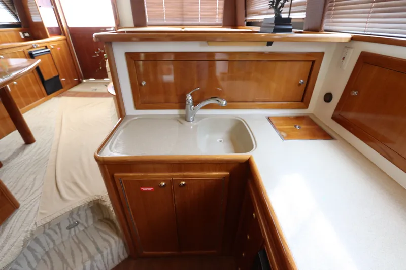 Slide: The Image of The 2001 Riviera 43 Open Flybridge kitchen features a sink and wooden cabinets. - 40