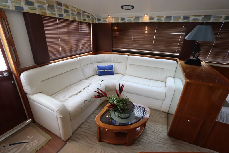 Slide: The Image of The image shows a luxurious seating area with white leather sofas and a wooden table on a boat. - 32