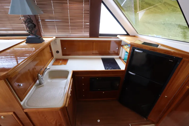 Slide: The Image of The 2001 Riviera 43 Open Flybridge galley features a sink, stove, and refrigerator. - 39
