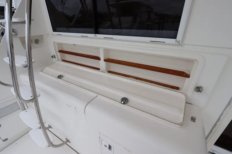 Slide: The Image of The image shows a white boat cabin with wooden shelves and a metal ladder. - 14