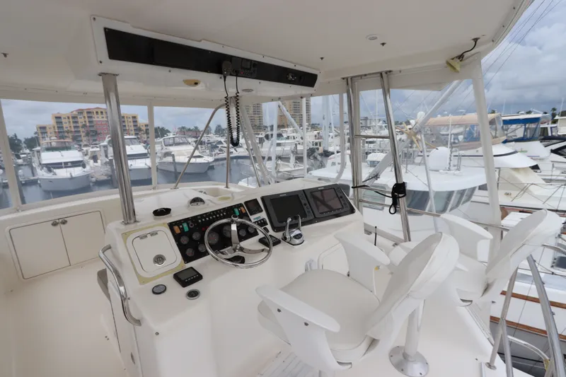 Slide: The Image of The image shows the helm of a 2001 Riviera 43 Open Flybridge with two white seats and a modern console. - 23