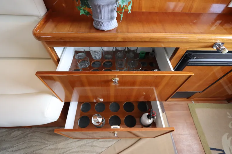 Slide: The Image of Wooden drawers with glasses and bottles, decorative plant on top. - 34