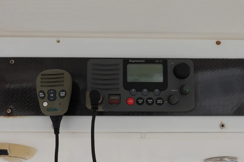 Slide: The Image of A Raymarine radio with microphone is mounted on a black console. - 28