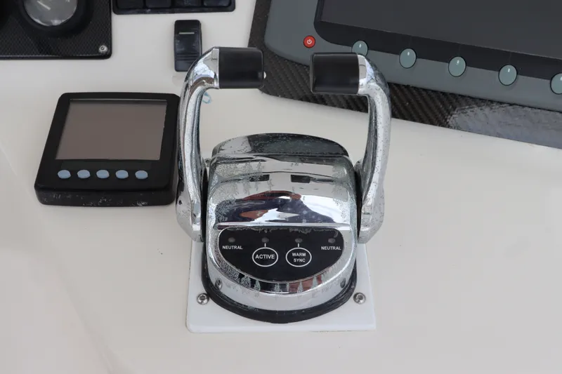 Slide: The Image of Close-up of the control console on a 2001 Riviera 43 Open Flybridge with chrome levers. - 25