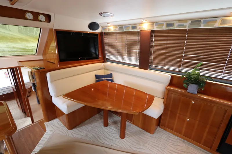 Slide: The Image of Interior of the 2001 Riviera 43 Open Flybridge with wooden table and beige seating. - 36