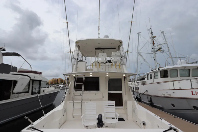 Slide: The Image of The 2001 Riviera 43 Open Flybridge is docked, featuring a spacious aft deck. - 18