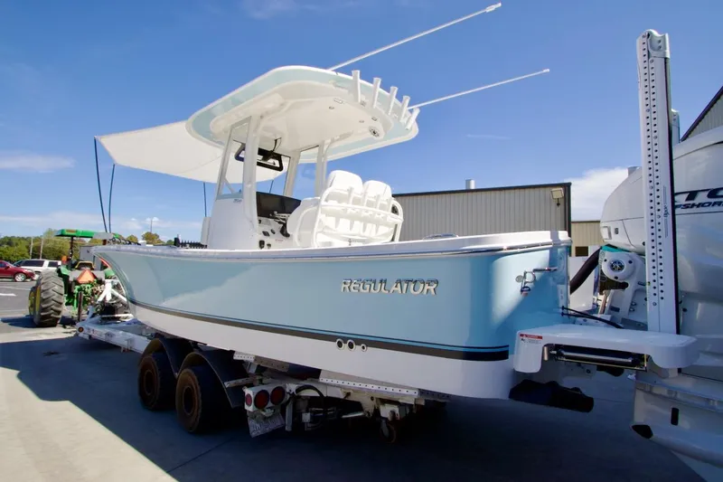 Slide: The Image of 2026 Regulator 26XO boat interior with open storage compartment and cushioned seating. - 11