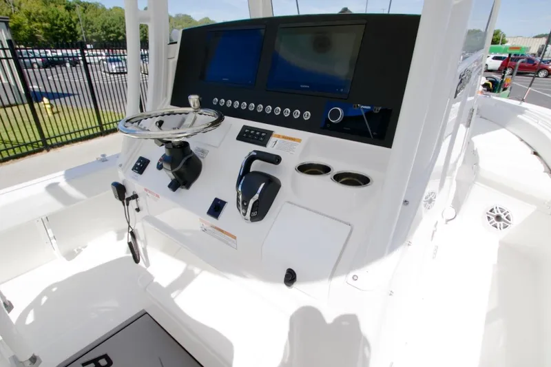 Slide: The Image of 2026 Regulator 26XO boat storage compartments and cup holders in white interior. - 23