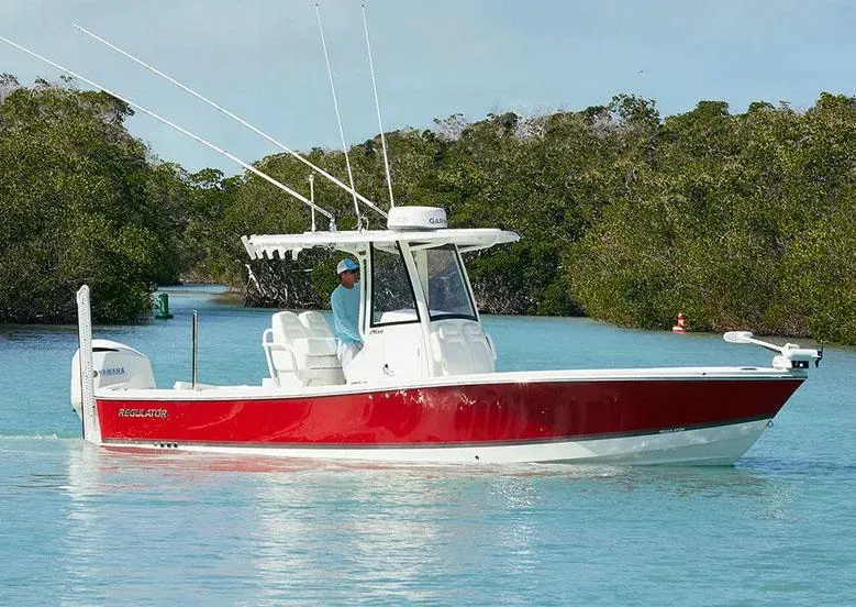 Slide: The Image of 2026 Regulator 26XO boat on trailer with canopy, parked outside a building. - 3