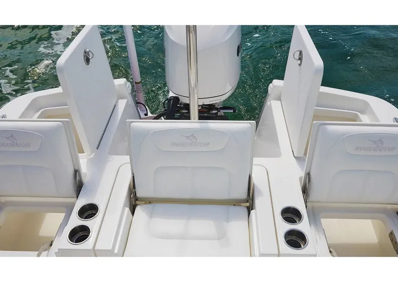 Slide: The Image of 2026 Regulator 26XO boat interior with white seating and speakers in a parking lot. - 8