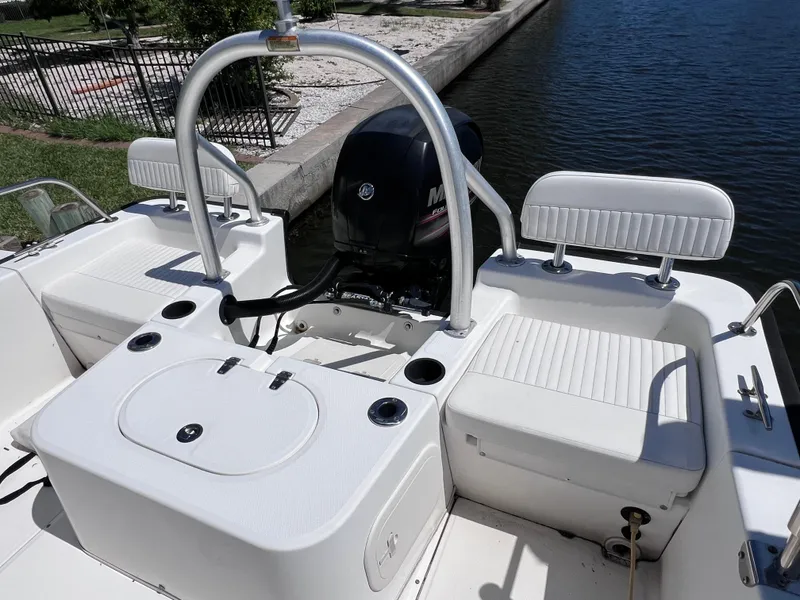 Slide: The Image of 2016 Boston Whaler 210 Montauk boat interior with seating and motor by the water. - 10