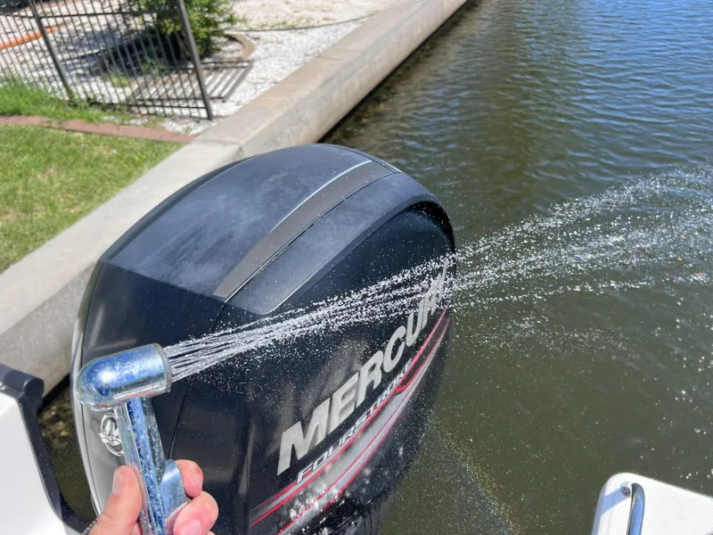 Slide: The Image of Washing a 2016 Boston Whaler 210 Montauk's Mercury outboard motor with a hose. - 24