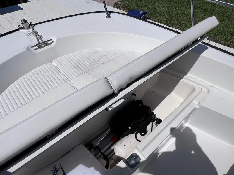 Slide: The Image of 2016 Boston Whaler 210 Montauk boat storage compartment with open lid and coiled rope inside. - 31