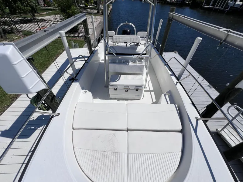Slide: The Image of 2016 Boston Whaler 210 Montauk boat interior with seating and console, docked by the water. - 33