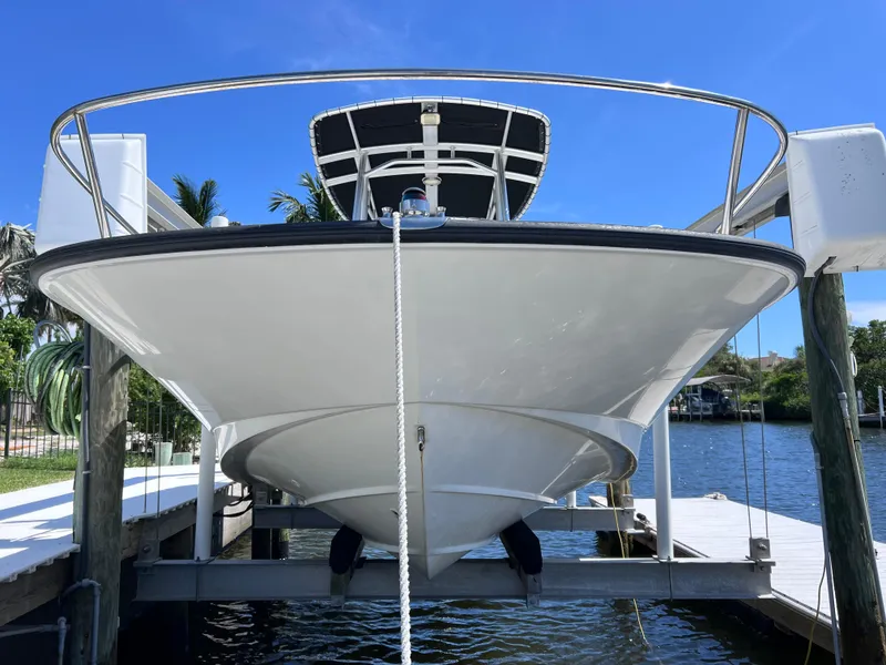 Slide: The Image of 2016 Boston Whaler 210 Montauk boat on lift, docked by waterfront. - 4