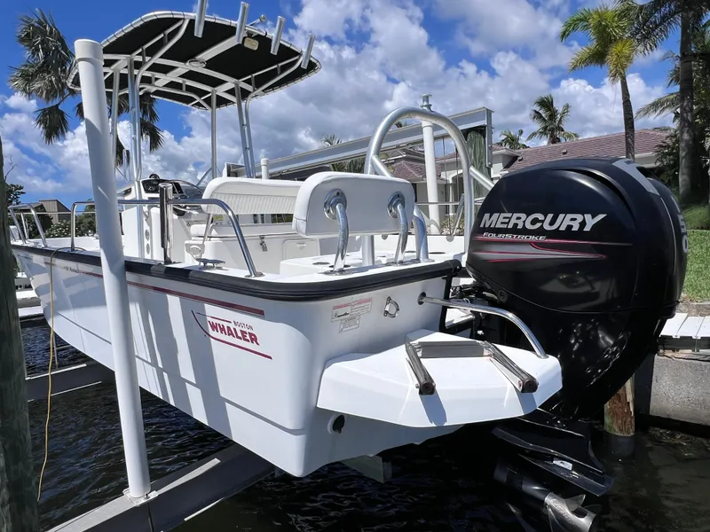Slide: The Image of 2016 Boston Whaler 210 Montauk boat with Mercury engine, docked under a sunny sky. - 7