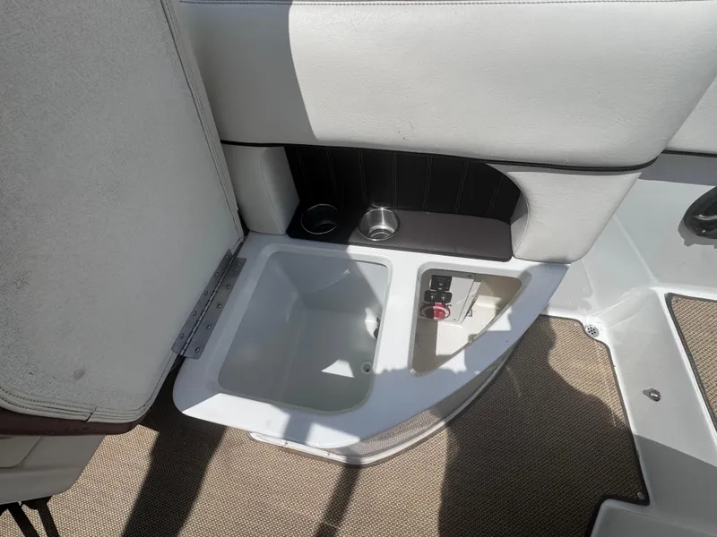Slide: The Image of 2013 Cobalt 24SD boat interior with storage compartment and cup holders. - 13