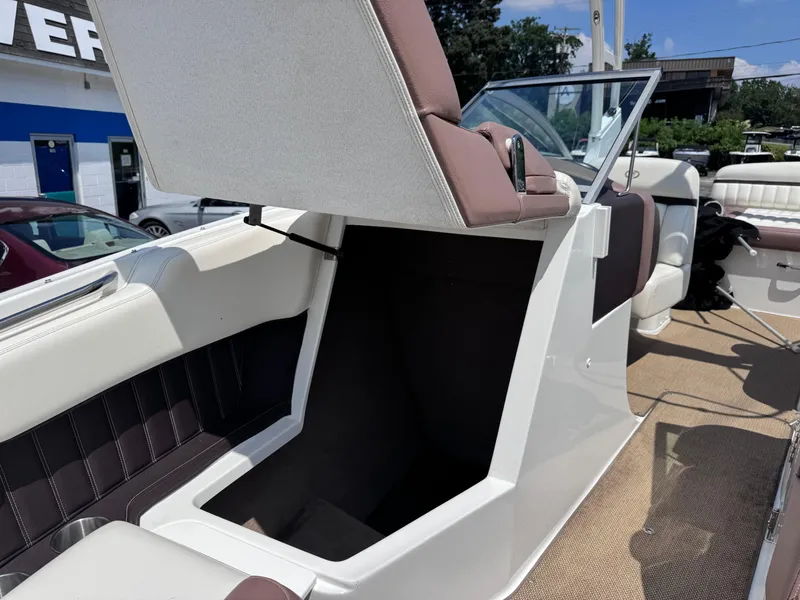 Slide: The Image of 2013 Cobalt 24SD boat interior with open storage compartment and seating. - 21