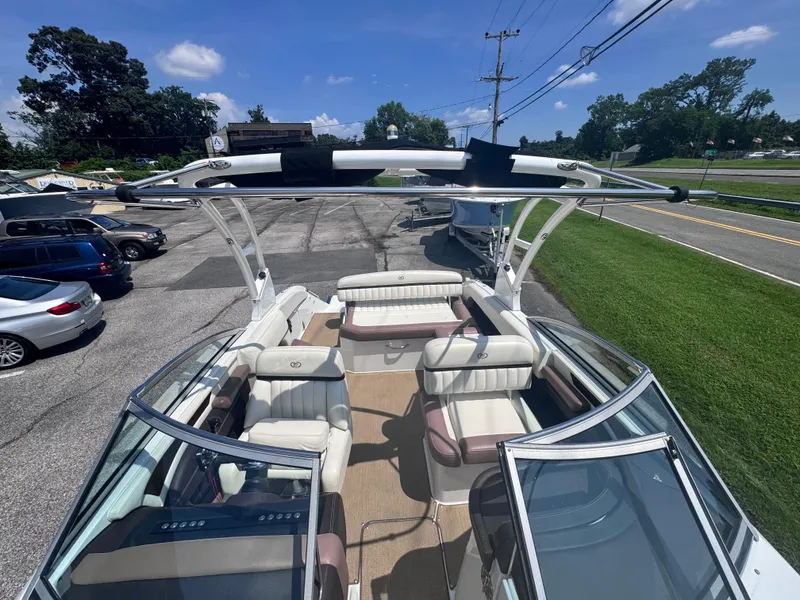 Slide: The Image of 2013 Cobalt 24SD boat with spacious seating, parked outdoors under clear skies. - 22