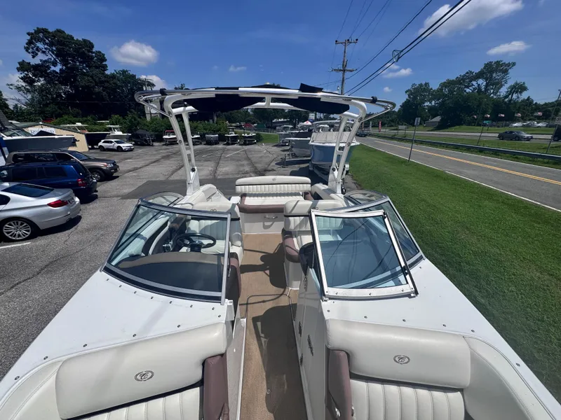 Slide: The Image of 2013 Cobalt 24SD boat with white seating, parked outdoors on a sunny day. - 23